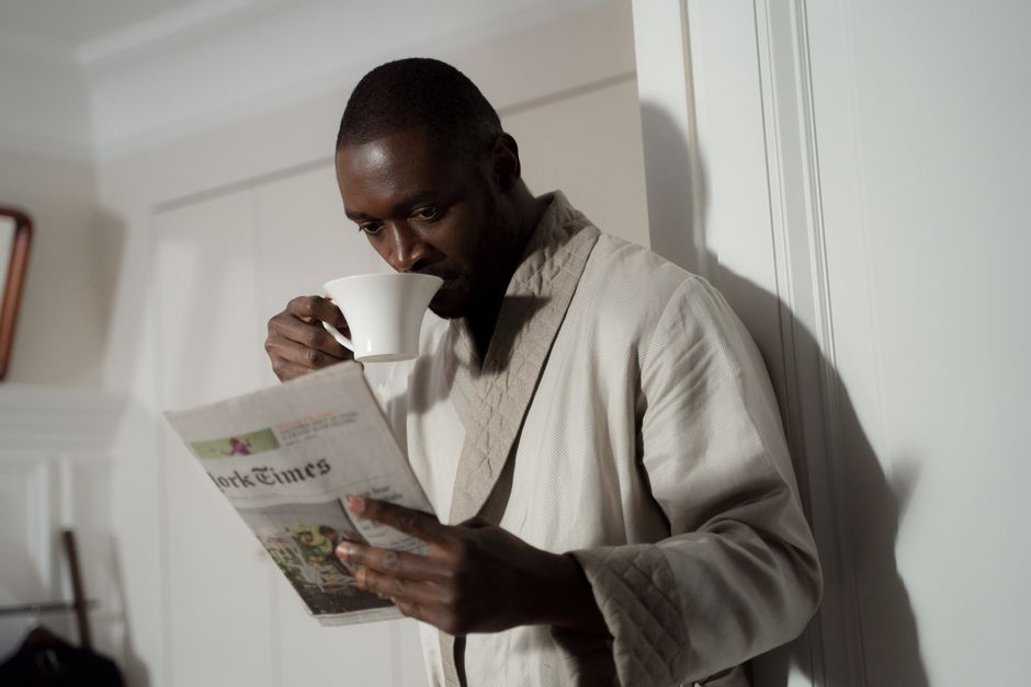 Lecteur parcourant la presse autour d'un café