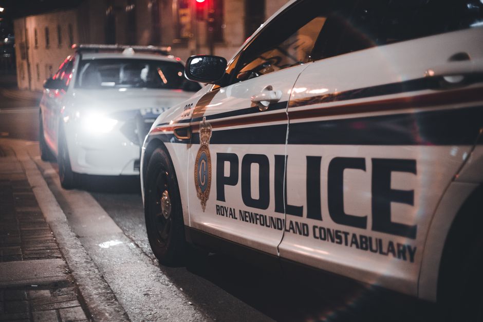 Vehículos de policía aparcados de noche frente a una comisaría