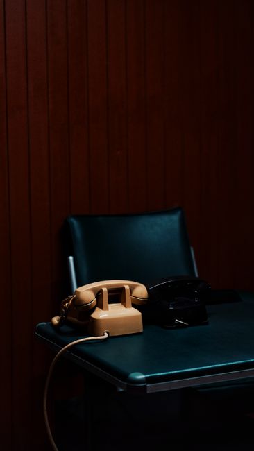 Vintage telephones on a desk in a dark setting