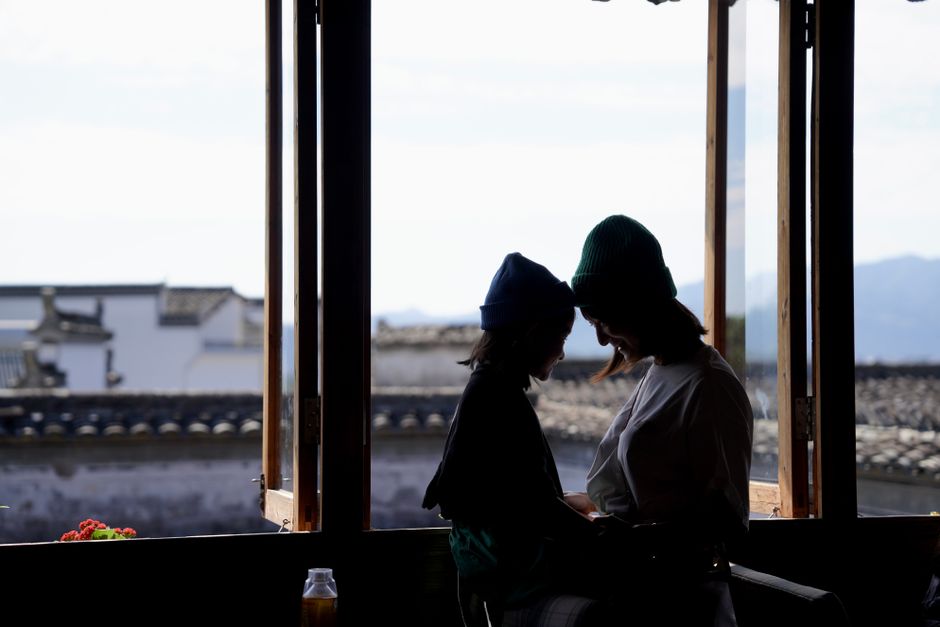 Siluetas de una madre y su hijo frente a una ventana