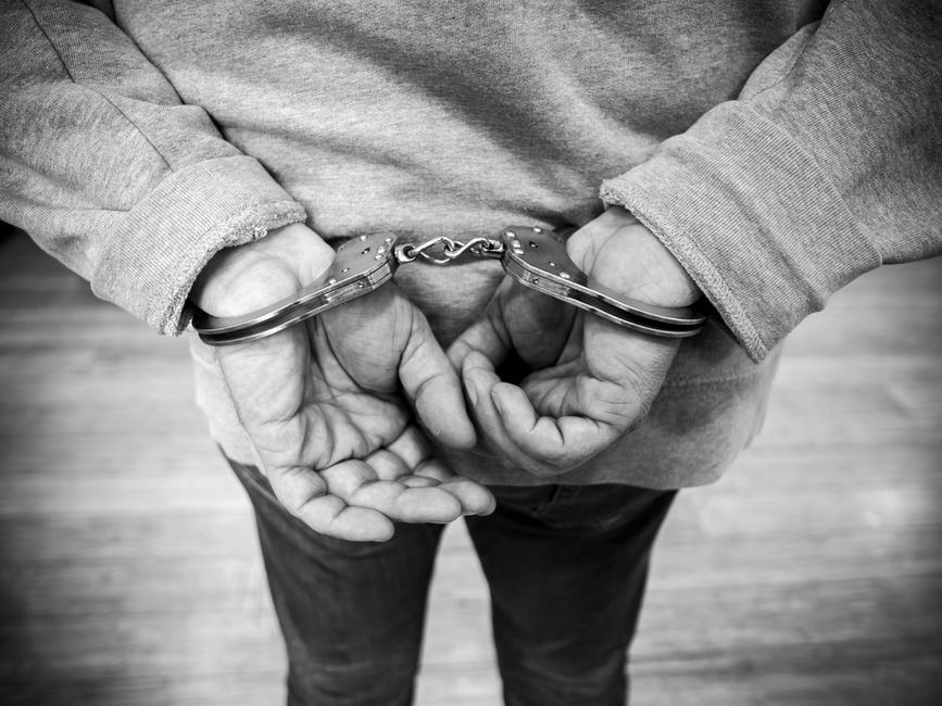 Persona esposada con las manos a la espalda durante una detención