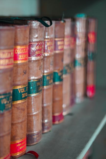Ouvrages de droit reliés alignés sur une étagère de bibliothèque juridique