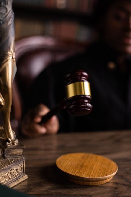 Juge frappant le marteau de justice à côté d'une statuette de la justice