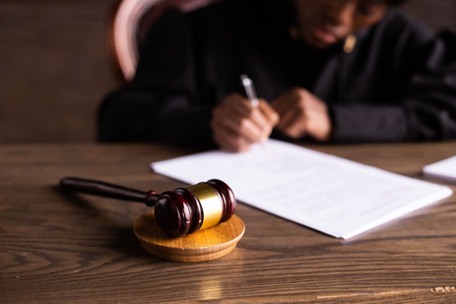 Magistrat signant une décision, marteau de justice au premier plan
