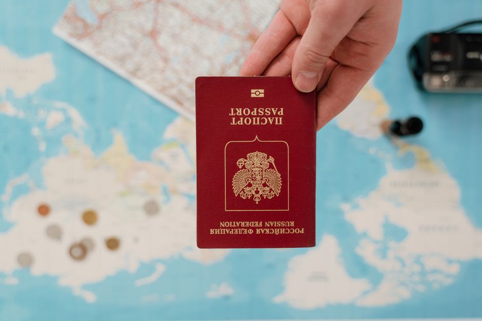 Passeport tenu au-dessus d'une carte du monde