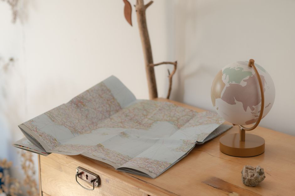 Carte routière dépliée à côté d'un globe terrestre