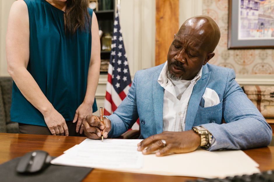 Firma de un documento en la oficina en presencia de una colaboradora